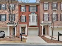 Inviting three-story townhome with a well-maintained brick facade and attached one car garage at 22 American Walk, Peachtree City, GA 30269