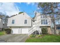 Inviting gray two-story home with a two-car garage and well-maintained front yard landscaping at 3813 Nowlin Nw Rd, Kennesaw, GA 30144