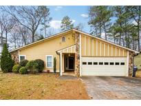 Charming one-story home features a garage, stone accents, and landscaped front yard at 1249 Herrington Rd, Lawrenceville, GA 30044