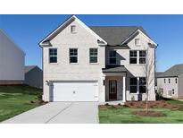 Charming two-story home with a white brick facade, a two-car garage, and a well-maintained lawn at 708 Ocmulgee Xing, Locust Grove, GA 30248