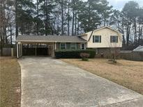 Charming home with a covered parking area and well-maintained front yard with mature landscaping at 5790 Northspring Dr, Ellenwood, GA 30294