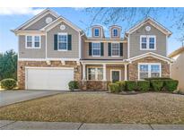 Charming two-story home with a stone and shingle facade and a well-manicured front yard at 1183 Lanier Springs Dr, Buford, GA 30518