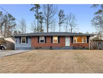 Charming single-story brick home with a manicured front lawn and a convenient carport at 1893 Kenwood Se Rd, Smyrna, GA 30082