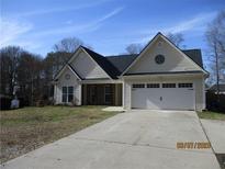 Charming single-story home features a two-car garage, well-manicured lawn, and inviting curb appeal at 561 Old Loganville Rd, Loganville, GA 30052