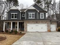Charming two-story home with dark siding, stone accents, white trim, and a three-car garage at 146 Riverbirch Way, Dallas, GA 30157