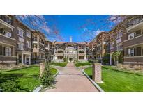 Attractive brick apartment buildings with arched entryway and well-manicured landscaping under a bright blue sky at 198 Ponce De Leon Ne Ave # 2A, Atlanta, GA 30308