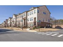 Charming townhome with brick facade and landscaped surroundings in a desirable community at 235 Commons Ave, Woodstock, GA 30188