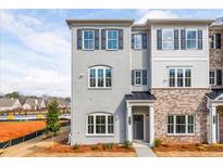 New construction exterior view of the townhome showcasing the brick and siding details and gray and white color scheme at 4810 Floydwood Ln, Mableton, GA 30126