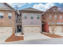 Charming townhome features a two-car garage, neutral siding, and a well-maintained front yard at 2275 W Village Se Ln, Smyrna, GA 30080