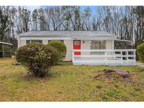 Charming single-story home featuring a red front door, white brick, carport, and a well-manicured lawn at 1899 Lathrop Se St, Atlanta, GA 30315