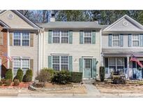 Inviting two-story townhome with light yellow siding and charming green shutters at 2280 Whitestone Pl, Alpharetta, GA 30005