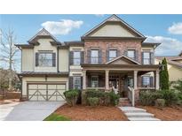 Charming two-story home featuring brick and siding exterior, front porch, and well-manicured landscaping at 4492 Arbor Crest Ct, Suwanee, GA 30024