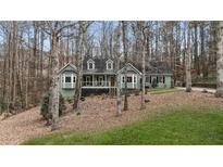Charming green home with a well-maintained yard and mature trees offering a peaceful setting at 90 Lakeside Dr, Hiram, GA 30141