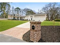 Charming ranch-style home with a manicured lawn, brick mailbox, and three-car garage at 185 Cold Creek Dr, Alpharetta, GA 30009