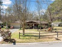 Charming one-story ranch with a welcoming front porch, mature trees, and a spacious front yard with wooden fence at 4544 Ridgeview Dr, Powder Springs, GA 30127