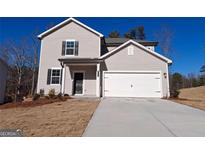 Charming two-story home featuring a two-car garage, neutral siding and a well-manicured front lawn on a sunny day at 7224 Lacey Dr, Douglasville, GA 30134