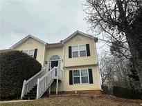 Inviting two-story home featuring a welcoming front porch and well-maintained landscaping at 2655 Fort Apachee Trl, Dacula, GA 30019