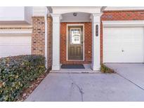 Inviting front door entrance with brick facade, white columns, and attached garage at 406 Patina Se # 23, Mableton, GA 30126