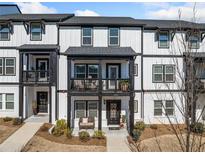Townhome exterior showcasing black and white facade, porches, and well-maintained landscaping at 1053 Knoxboro Ln, Woodstock, GA 30188