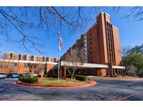 Apartment complex with brick facade, manicured landscaping, and American flag at 300 Johnson Ferry Ne Rd # B113, Atlanta, GA 30328