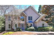 Charming two-story home showcasing a stone-accented facade and a well-manicured front yard at 10860 Donamere Dr, Johns Creek, GA 30022