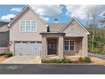 Charming home with a two-car garage, brick facade, covered porch, and well-maintained landscaping at 119 Ivey Way, Woodstock, GA 30188