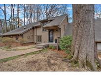 Charming home featuring a unique facade, front yard landscaping, and mature trees at 4144 D Youville Trce, Atlanta, GA 30341