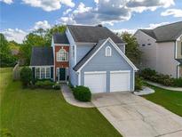 Charming two-story home featuring a two-car garage and a well-manicured lawn at 5060 Amber Leaf Dr, Roswell, GA 30076
