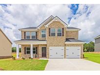 Beautiful two-story home with stone and brick exterior, two-car garage, and well-manicured lawn at 1587 Sungrown Way, Mcdonough, GA 30253