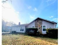 Charming home exterior features stone accents and a well-maintained front lawn under a bright sky at 4906 Kellys Mill Nw Dr, Lilburn, GA 30047