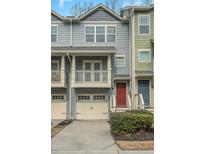 Two-story townhome featuring a balcony, red front door, and an attached one-car garage at 1281 Liberty Nw Pkwy, Atlanta, GA 30318