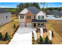 Charming two-story home featuring brick and siding, complemented by a well-manicured lawn at 1645 Fuma Leaf Way, Mcdonough, GA 30253
