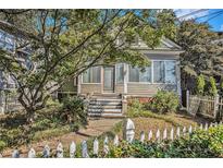 Charming home featuring a quaint picket fence, lush landscaping, and welcoming front porch at 1200 Dekalb Ave, Atlanta, GA 30307