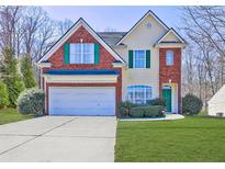 Charming two-story home with brick accents, a two-car garage, and well-maintained lawn and landscaping at 1600 Brisbane Drive, Dacula, GA 30019