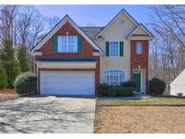 Charming two-story home featuring a two-car garage, red brick, and attractive landscaping at 1600 Brisbane Drive, Dacula, GA 30019