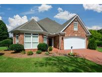 Charming brick home featuring manicured landscaping, a two-car garage and a welcoming front entrance at 2392 Ivy Mountain Dr, Snellville, GA 30078