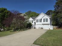 Charming home with a white exterior, black shutters, and a spacious driveway surrounded by green lawns at 4184 Wyndham Park Way, Buford, GA 30519