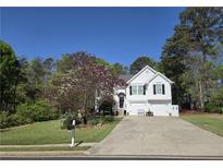 Charming two-story home with a well-manicured lawn, double garage, and flowering tree at 4184 Wyndham Park Way, Buford, GA 30519
