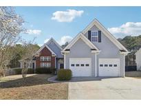Charming home featuring a two-car garage, beautiful landscaping, and a mix of brick and siding exterior at 1925 Meyers Dr, Lawrenceville, GA 30045