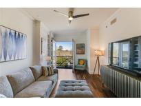 Bright living room featuring a cozy sofa, balcony access, hardwood floors, and stylish decor at 2277 Peachtree Ne Rd # 608, Atlanta, GA 30309