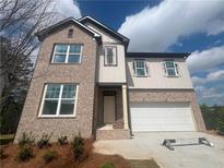 Two-story home boasts a brick facade, attached garage, and a welcoming entrance at 630 Gilles Ln, Cumming, GA 30041