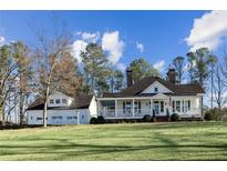Charming white home with a welcoming porch and manicured lawn against a blue sky backdrop at 1325 Whitlock Sw Ave, Marietta, GA 30064