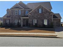 Charming two-story brick home with lush landscaping and a welcoming front entrance at 3671 Casual Ridge Way, Loganville, GA 30052