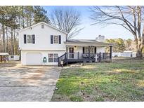 Charming split-level home showcasing a welcoming front porch and well-maintained front yard at 916 Marshall Fuller Rd, Dallas, GA 30157