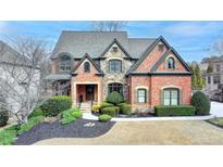 Charming brick home featuring stone accents, a well-manicured lawn, and a welcoming front entrance at 5340 Cole Creek Ln, Cumming, GA 30040