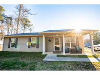 Charming single-story home with a covered porch and manicured lawn at 885 Green Valley Dr Nw, Conyers, GA 30012