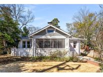 Charming bungalow home with a white brick facade and a beautifully landscaped front yard at 1290 Oxford Ne Rd, Atlanta, GA 30306