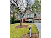 Charming two-story brick home with a well-manicured lawn and mature trees at 709 Eastwood Rise, Stone Mountain, GA 30087