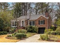 Charming brick home with a well-manicured front yard and mature trees offering shade and curb appeal at 1881 Edinburgh Ne Ter, Atlanta, GA 30307