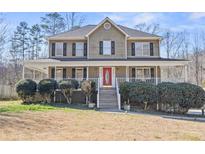 Charming two-story home features a welcoming front porch and manicured landscaping at 327 Swan Dr, Hiram, GA 30141